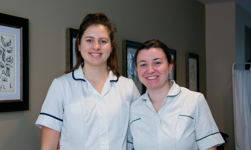 Two members of staff smiling